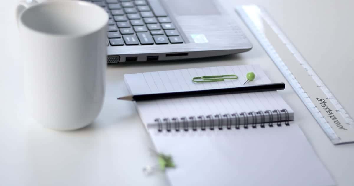 Laptop, notebook and coffee mug on a founder's desk