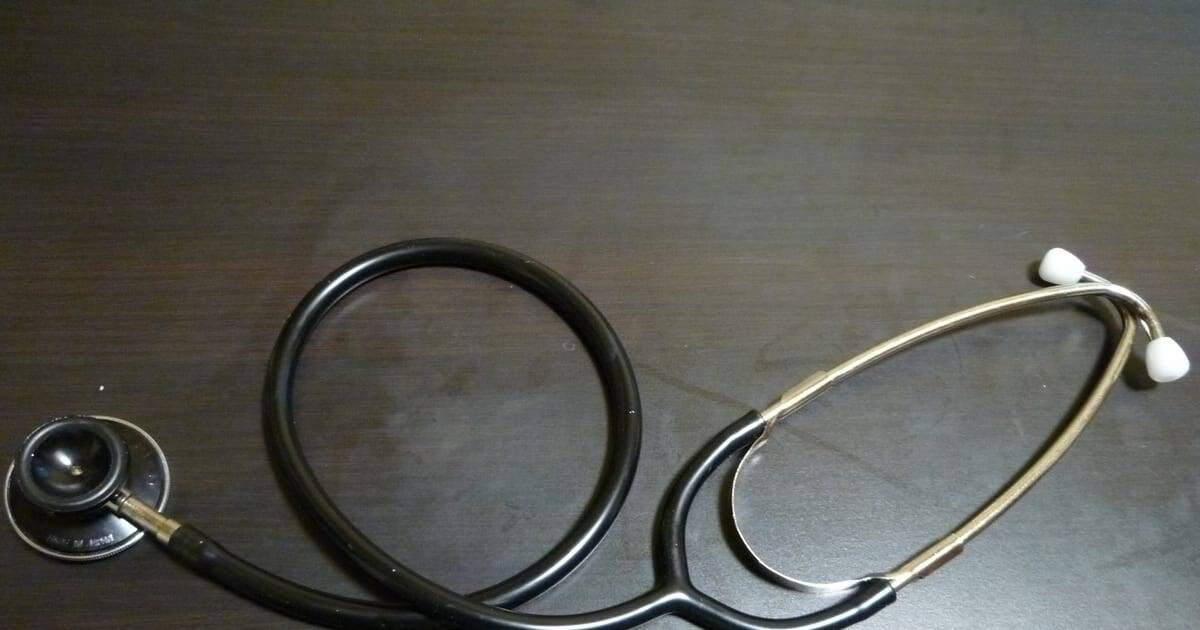 Stethoscope on a wooden desk in a medical clinic Stethoscope on a wooden desk in a medical clinic